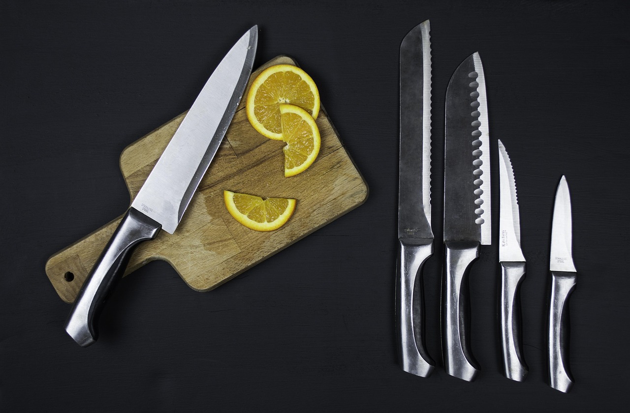 Sharp knives and kitchen tools laid out on a chopping board